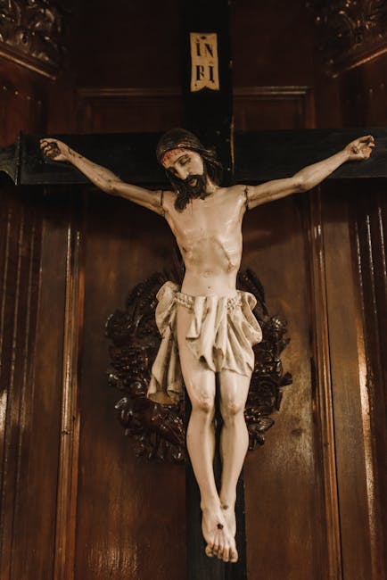 Close-up of a detailed sculpture of Jesus crucified on a cross in a church setting.